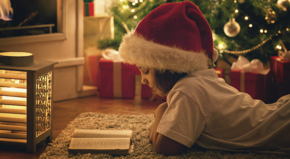 bambina natale inverno leggere libro albero regali candela lettrice