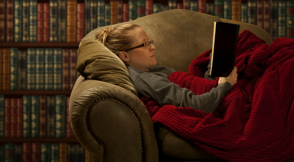 leggere libro inverno divano casa lettrice lettore letto coperta natale