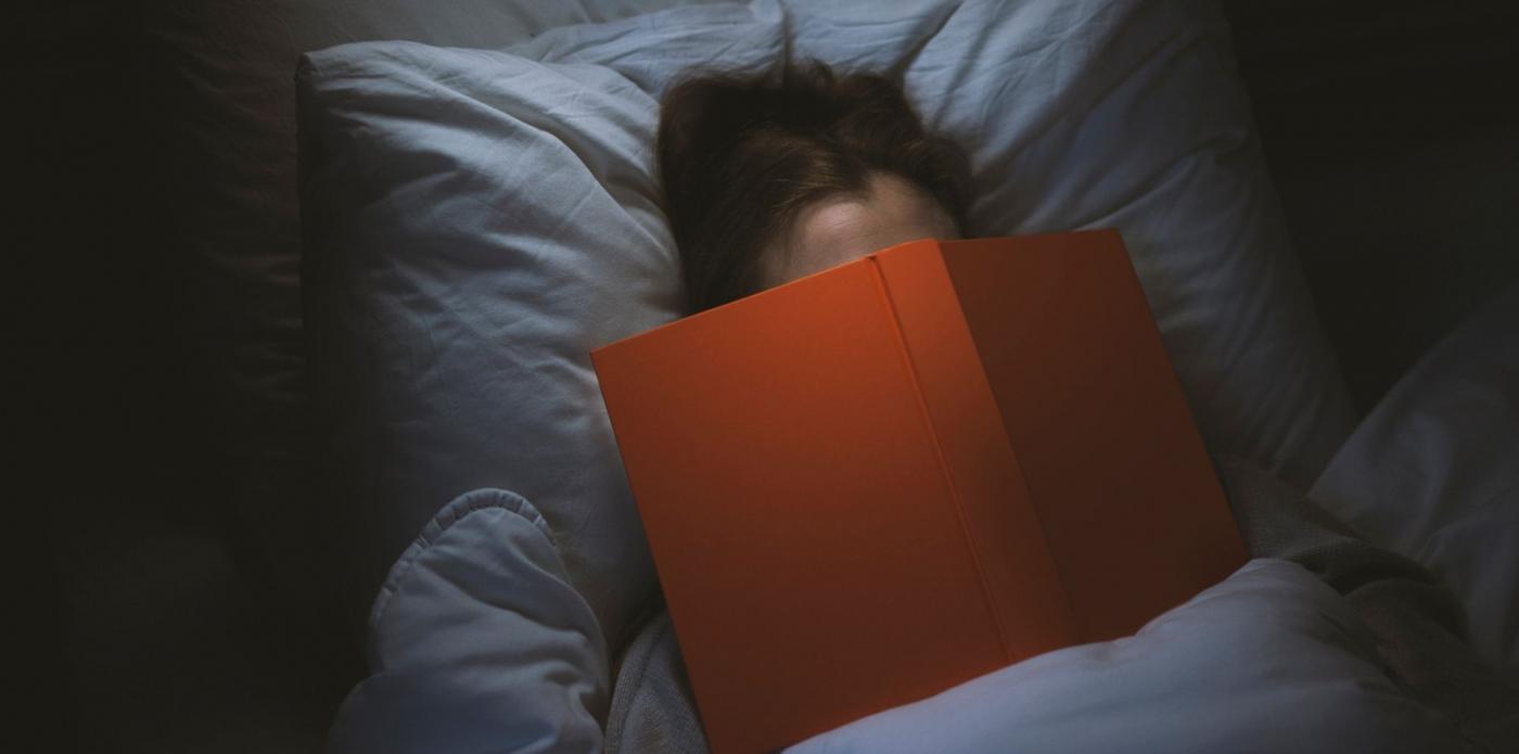 Una ragazza legge un libro a letto