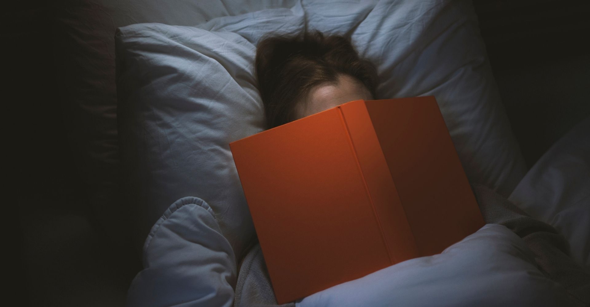 Una ragazza legge un libro a letto