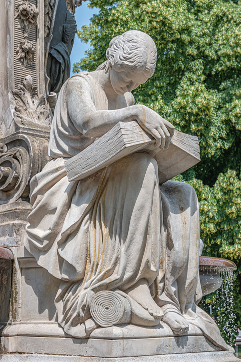 Statua di ispirazione classica di una ragazza che legge un libro