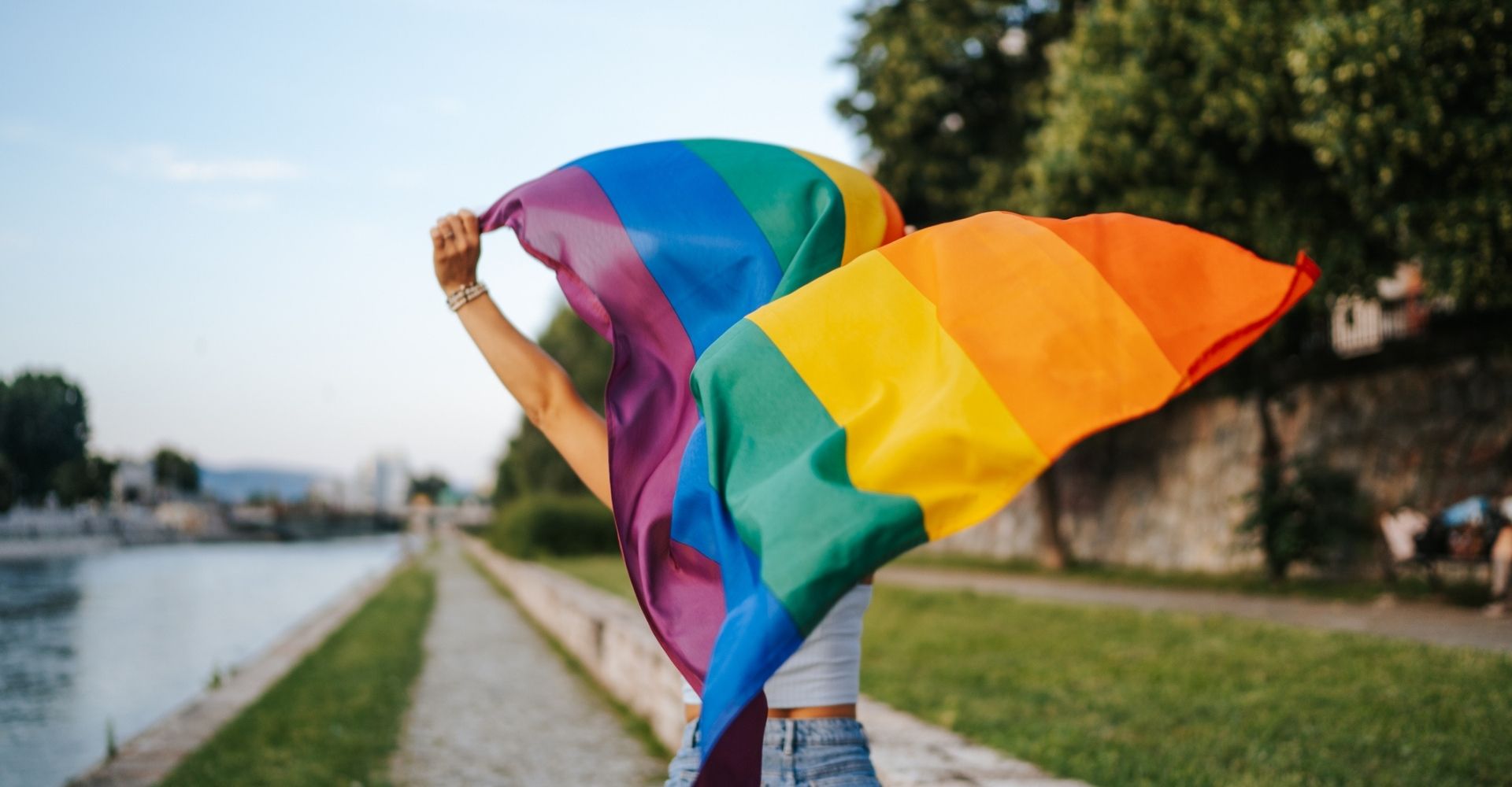 una ragazza sventola la bandiera arcobaleno, simbolo del movimento lgbtq+