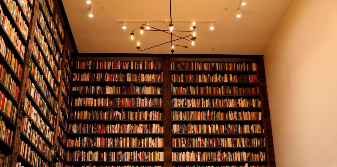 Vista di una libreria a muro con gli scaffali pieni di libri