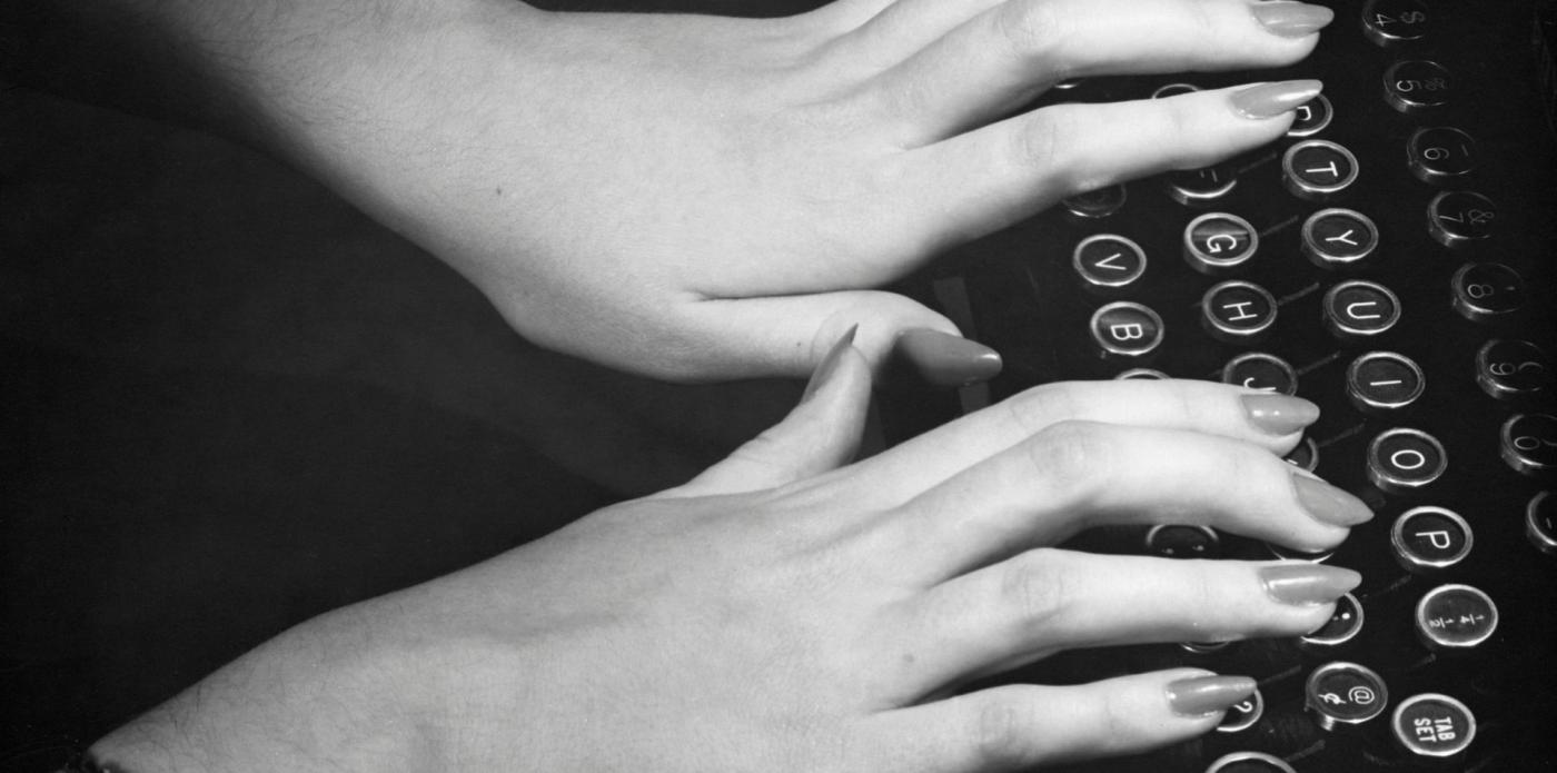 Vista di due mani di donna che digitano su una macchina da scrivere
