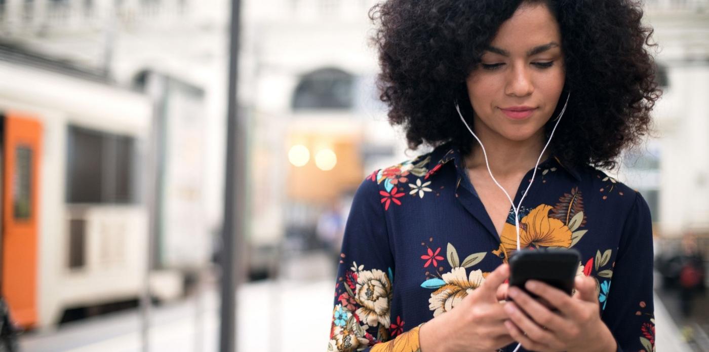 Ragazza che ascolta un podcast o audiolibro per strada