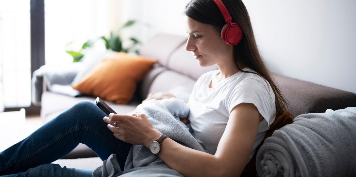 Ragazza che ascolta un podcast o audiolibro per strada sul divano