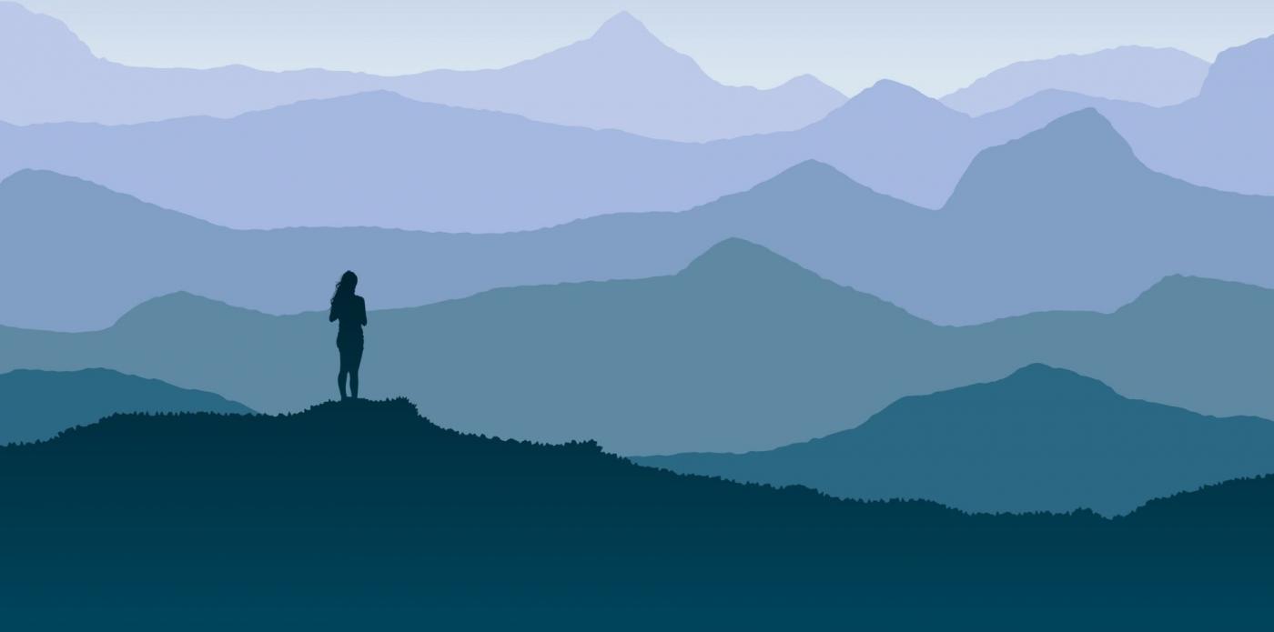 Una ragazza guarda sulla cima di una montagna un orizzonte blu