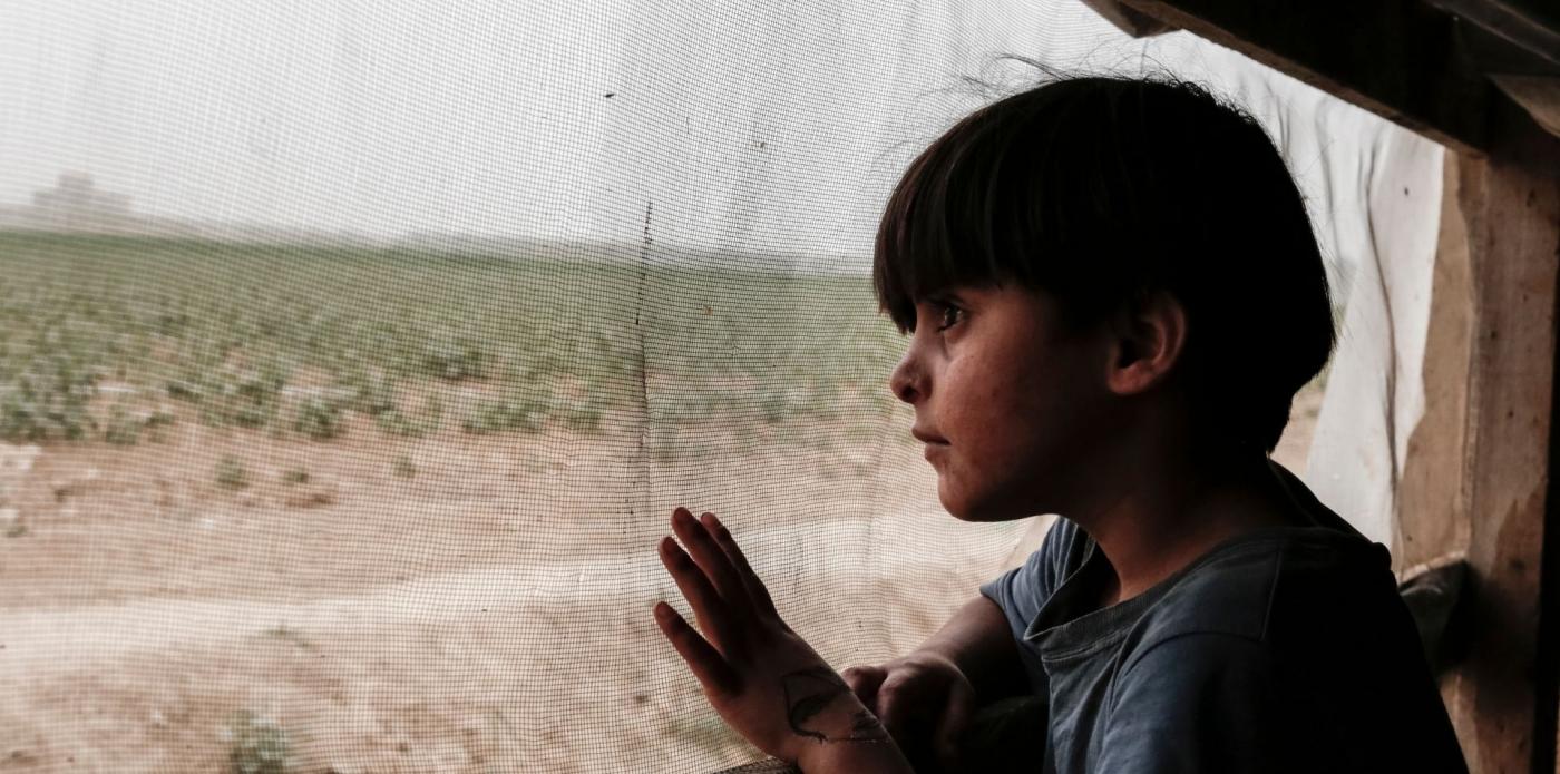 Un bambino in Libano guarda il paesaggio da un finestrino