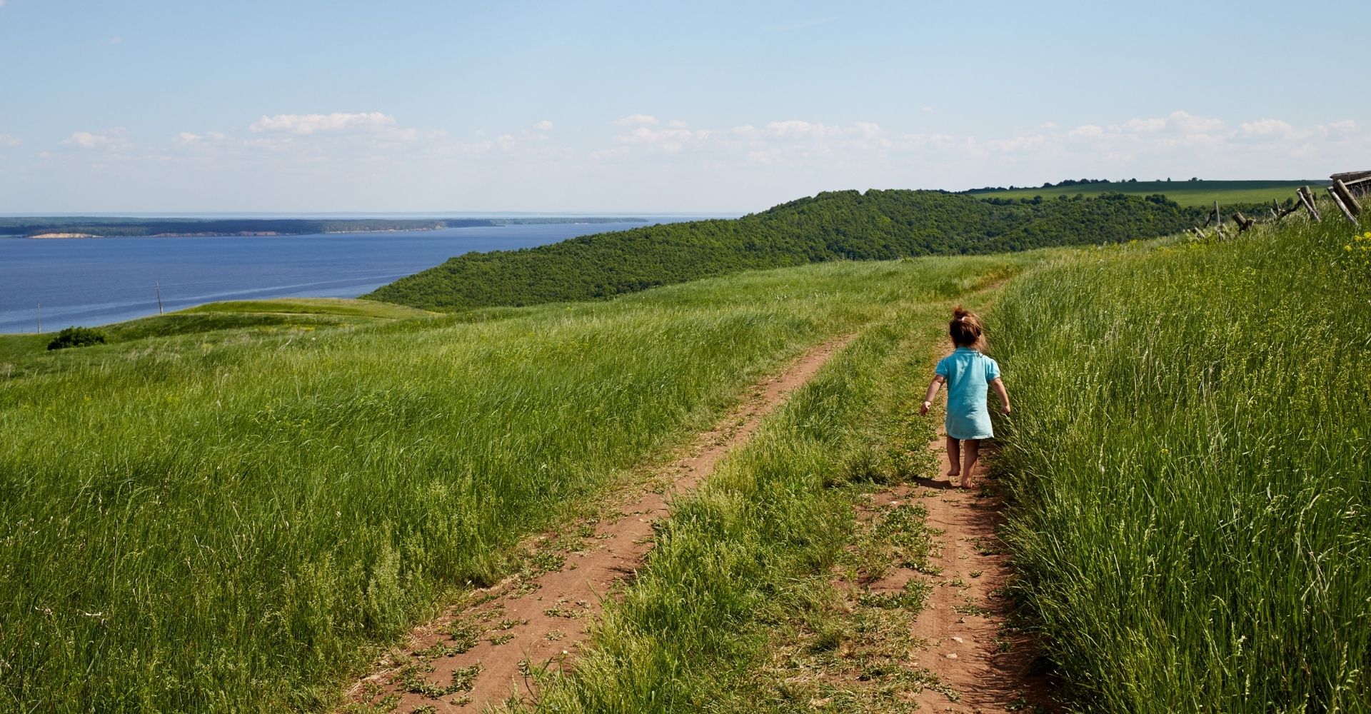 Una bambina cammina su un prato vicino al fiume Volga