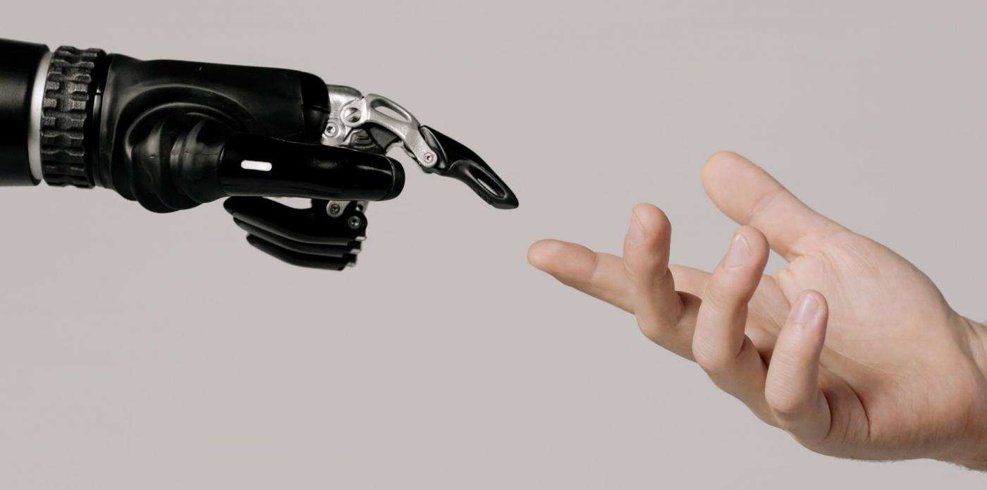 Il dito di una mano robot e quello di una mano umana che si sfiorano