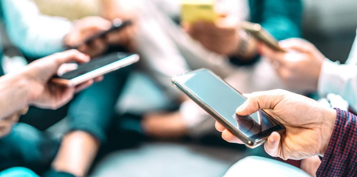 Un gruppo di persone che guardano il loro smartphone