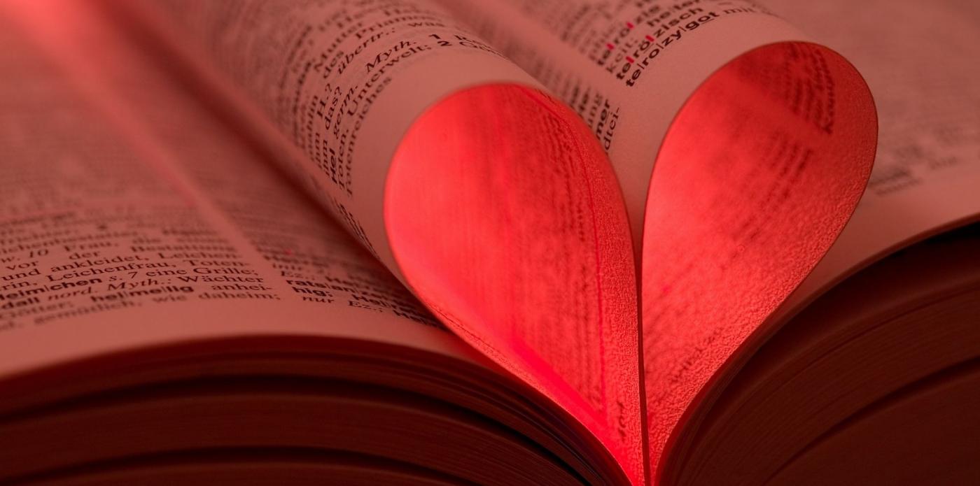 Un cuore di carta creato piegando le pagine di un libro aperto
