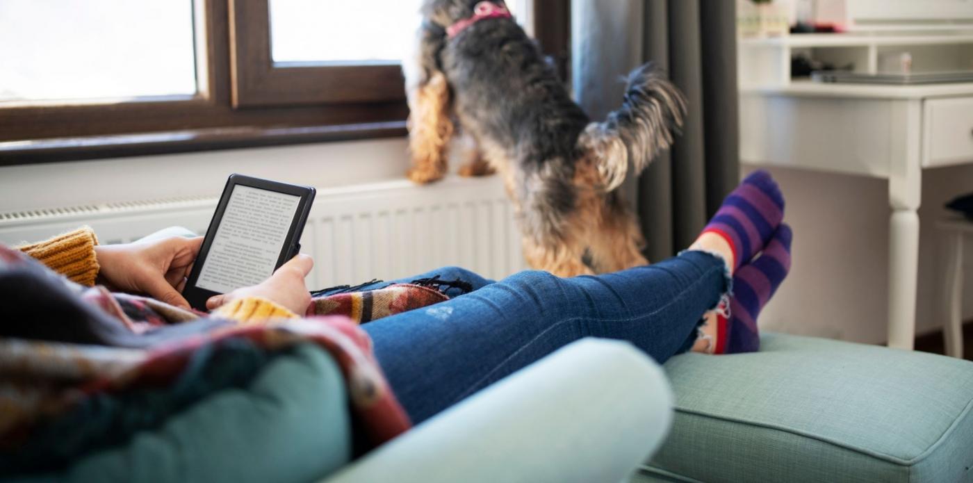 Donna ragazza lettrice adolescente leggere lettura interno casa inverno ebook ereader digitale cani animali