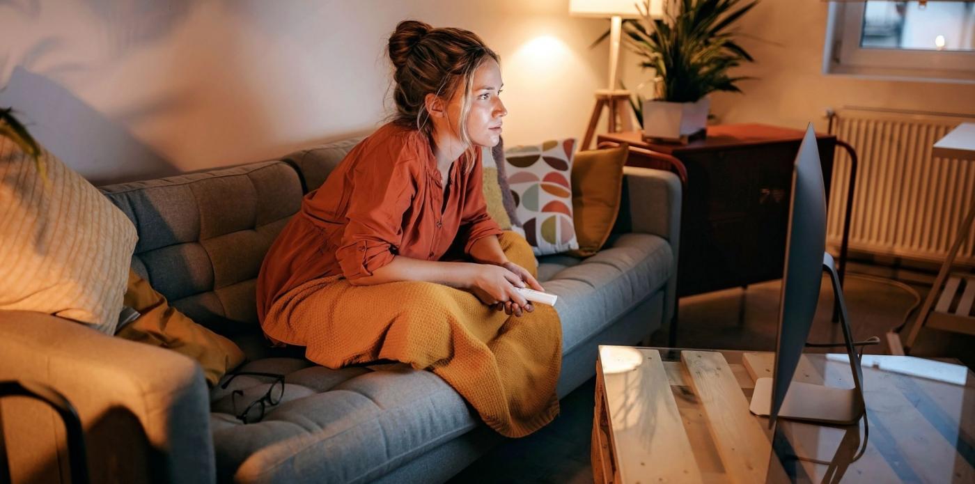 Una ragazza guarda una serie tv seduta sul divano