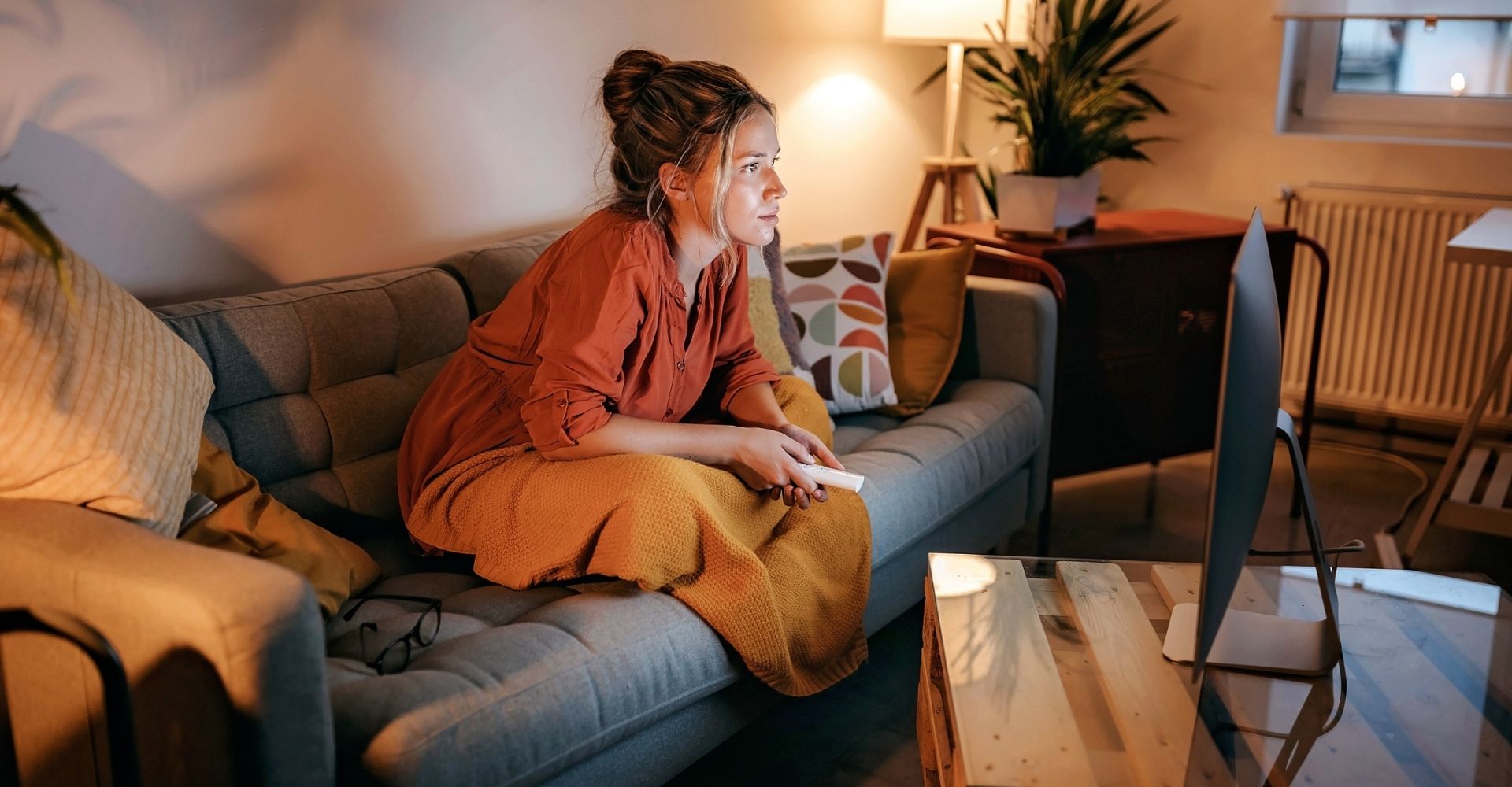 Una ragazza guarda una serie tv seduta sul divano