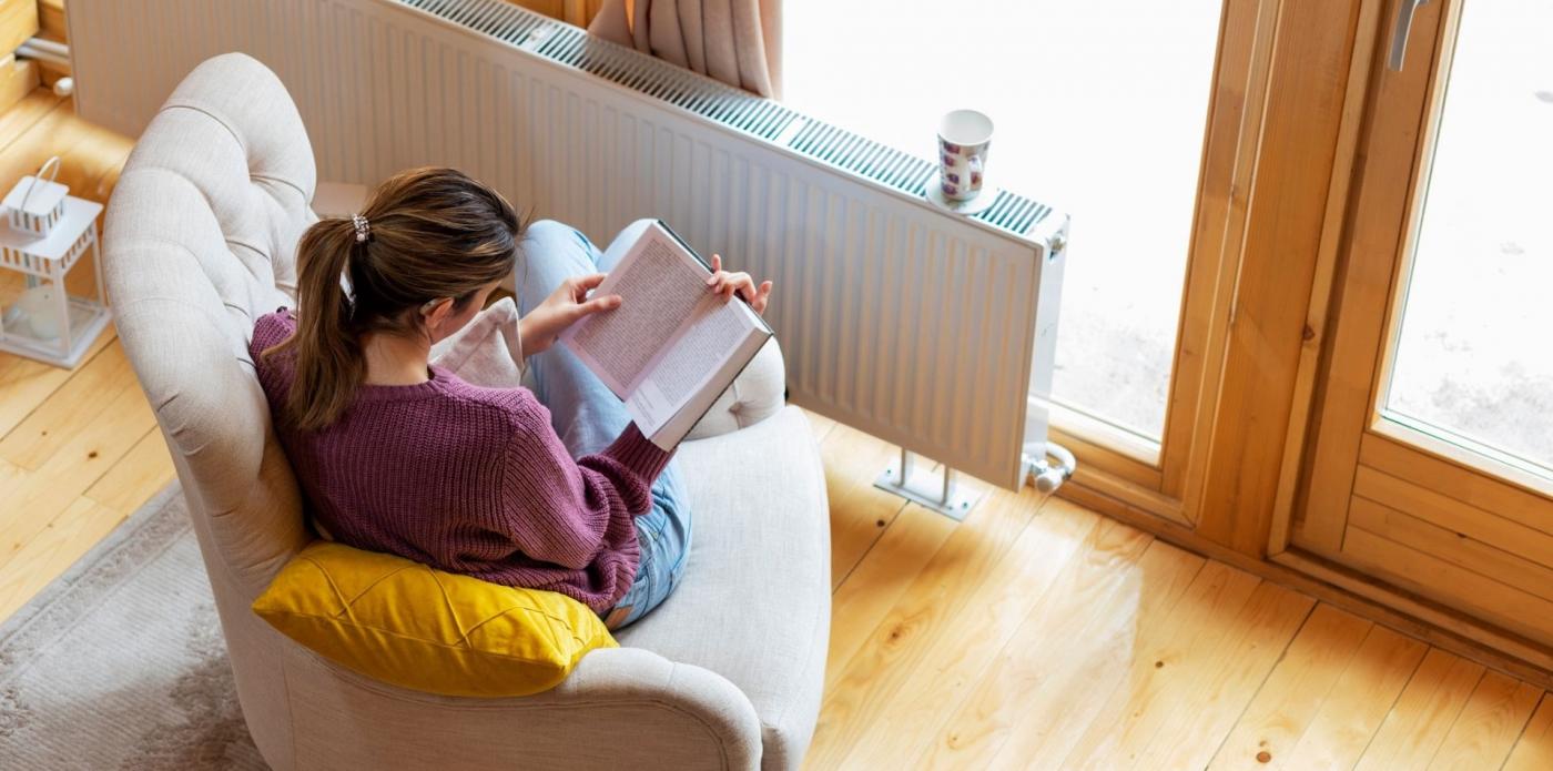 donna che legge un libro sotto la neve inverno freddo