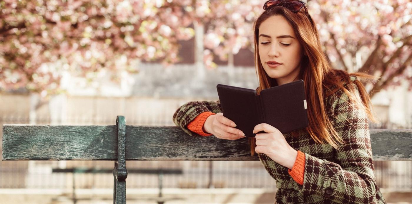 Giovane donna legge lettura ebook primavera parco panchina