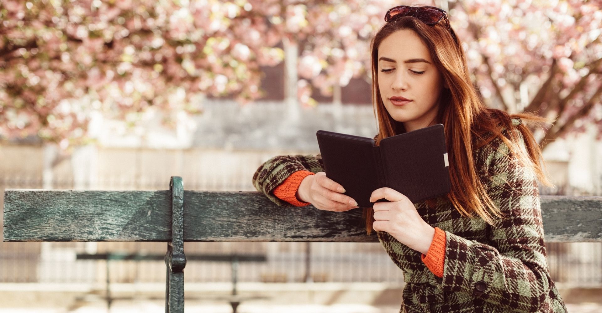 Giovane donna legge lettura ebook primavera parco panchina