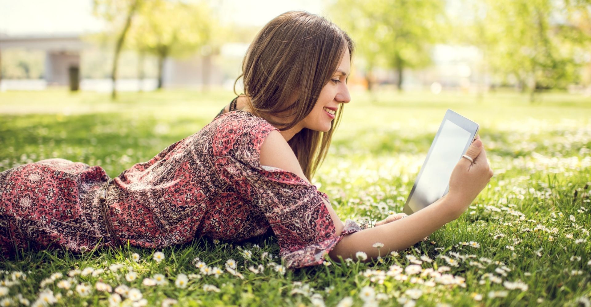 Giovane donna legge lettura ebook primavera parco prato fiori