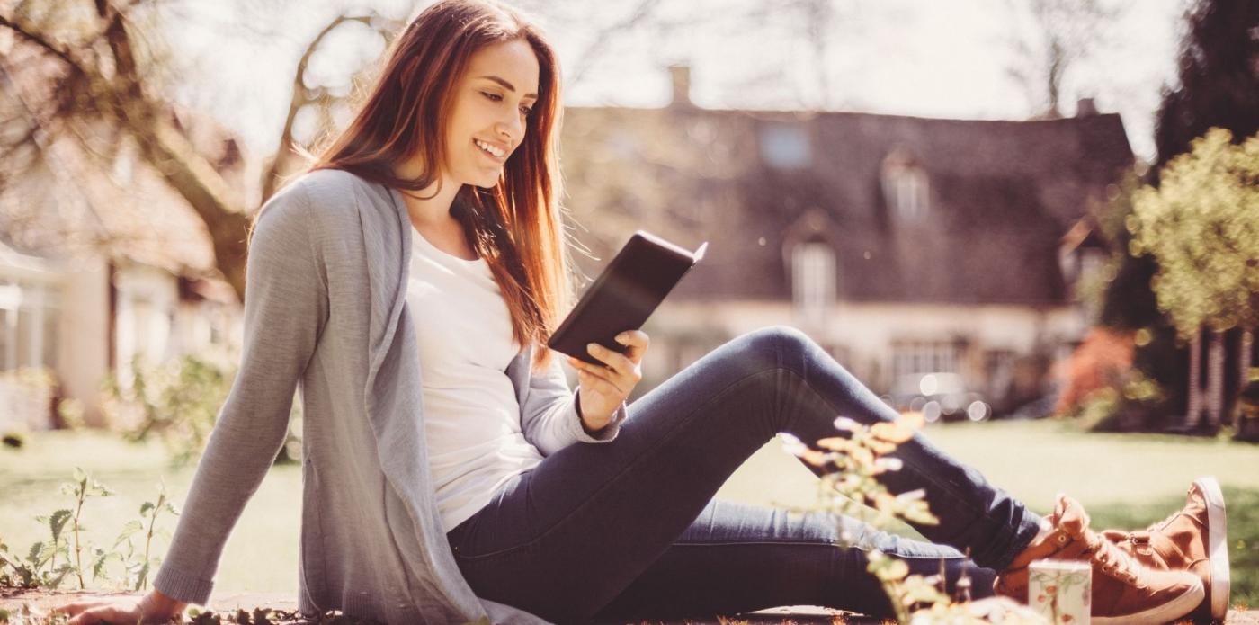 Giovane donna legge lettura ebook primavera parco