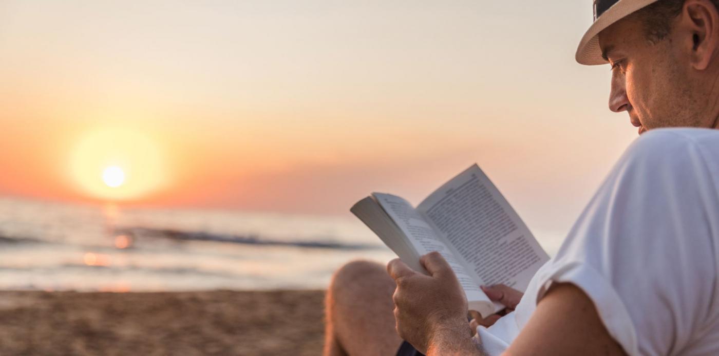 uomo legge libro spiaggia lettura estate libri lettore