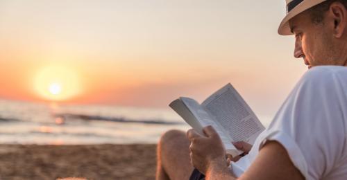 uomo legge libro spiaggia lettura estate libri lettore