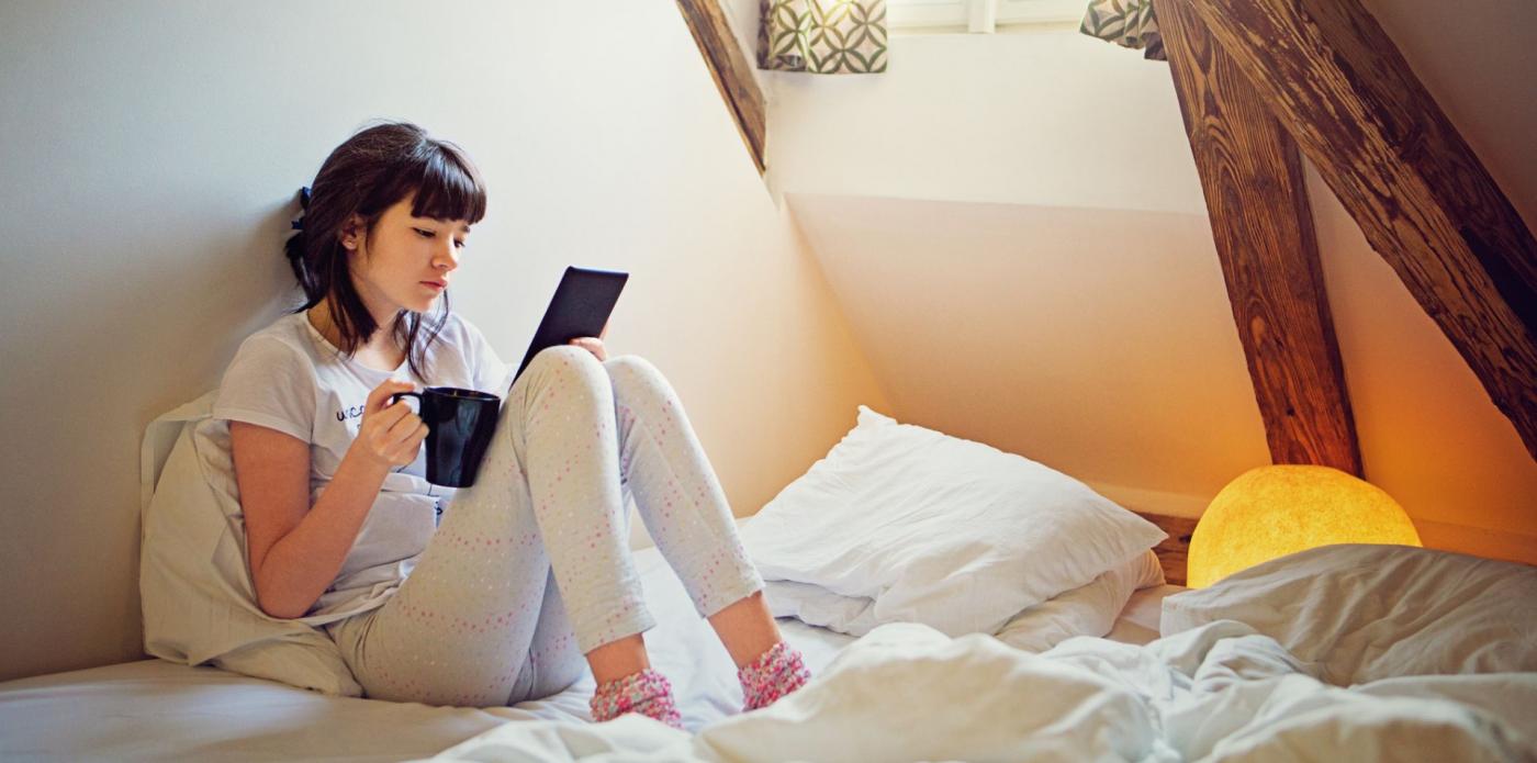 leggere ebook e-book libro digitale libri ragazza giovane legge libro lettori lettrici lettrice casa tazza
