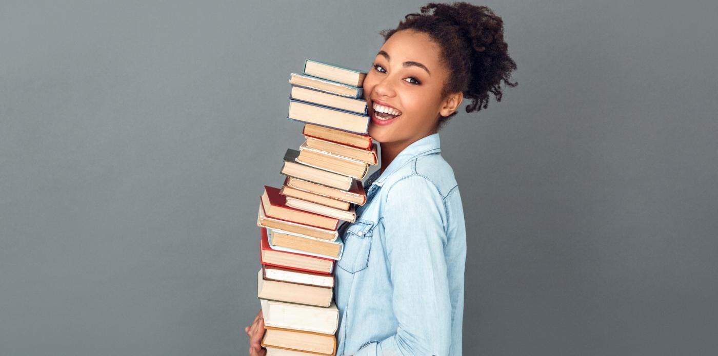 lettura libri ragazza adolescente giovane legge libro lettori lettrici lettrice pila di libri