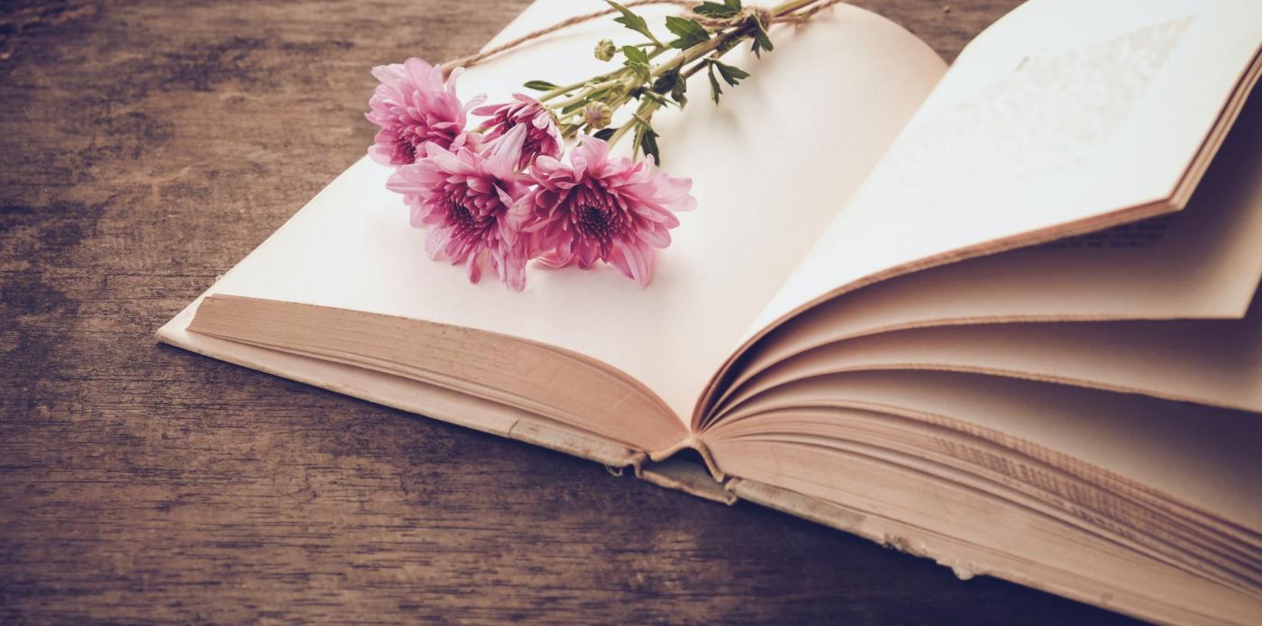 Un mazzo di fiori appoggiato su un libro aperto