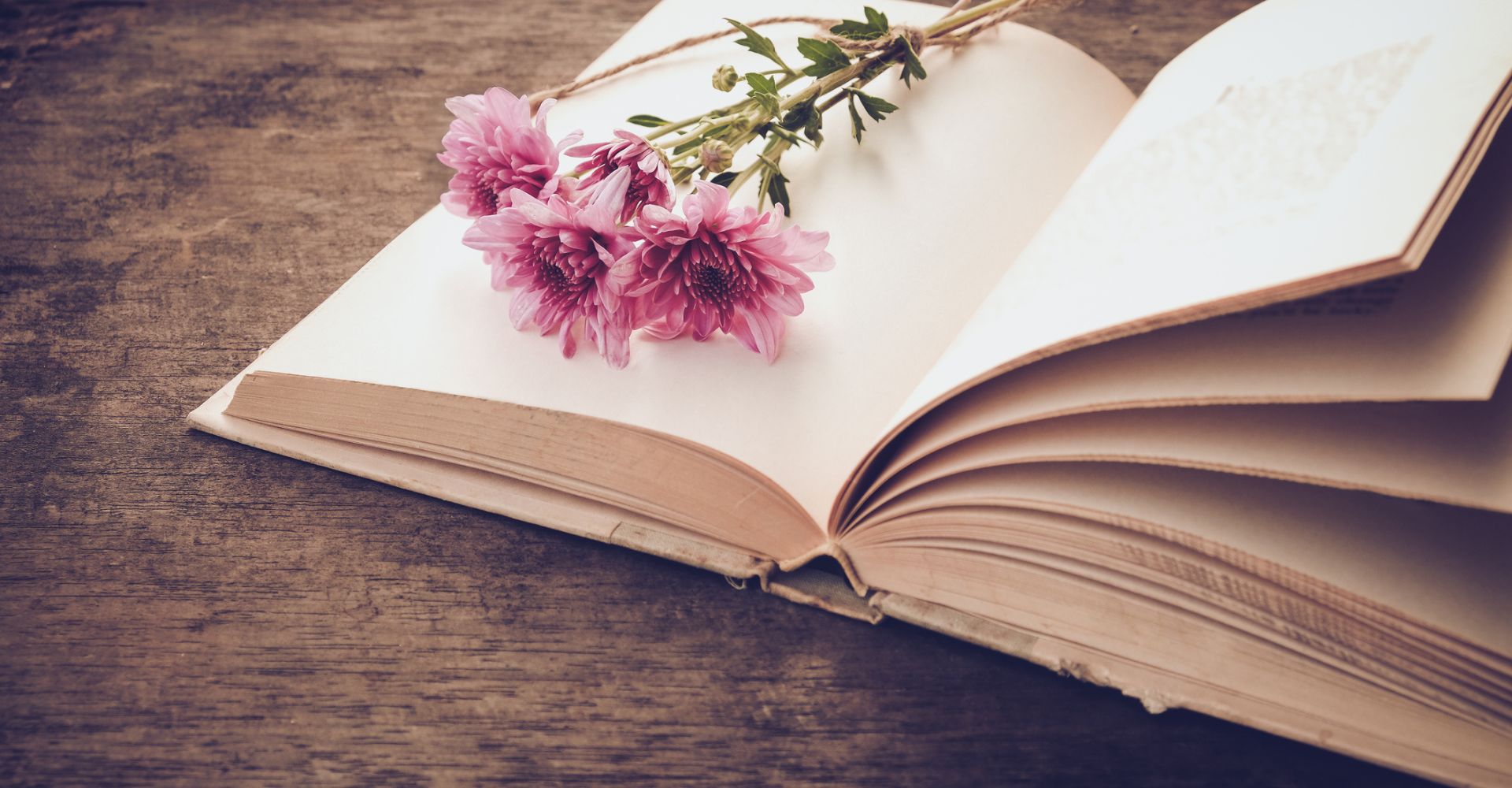 Un mazzo di fiori appoggiato su un libro aperto