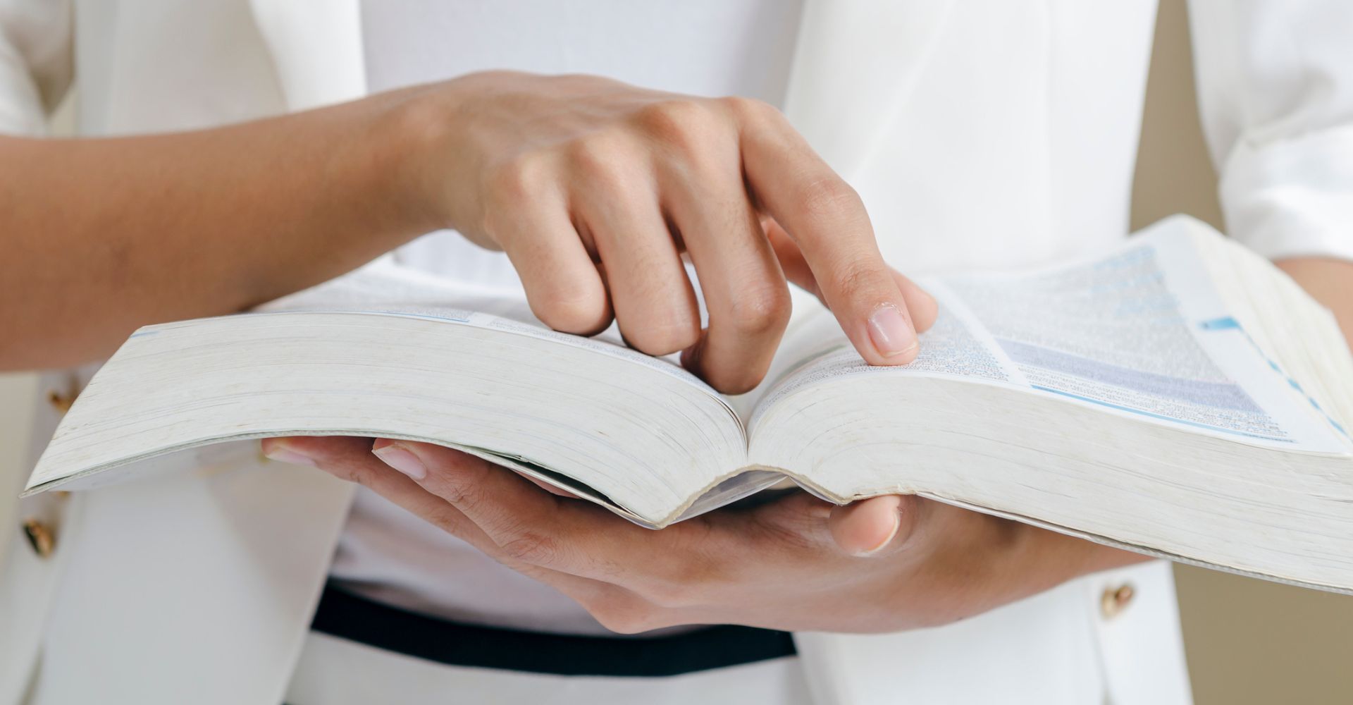 Una ragazza tiene tra le mani e sfoglia un dizionario