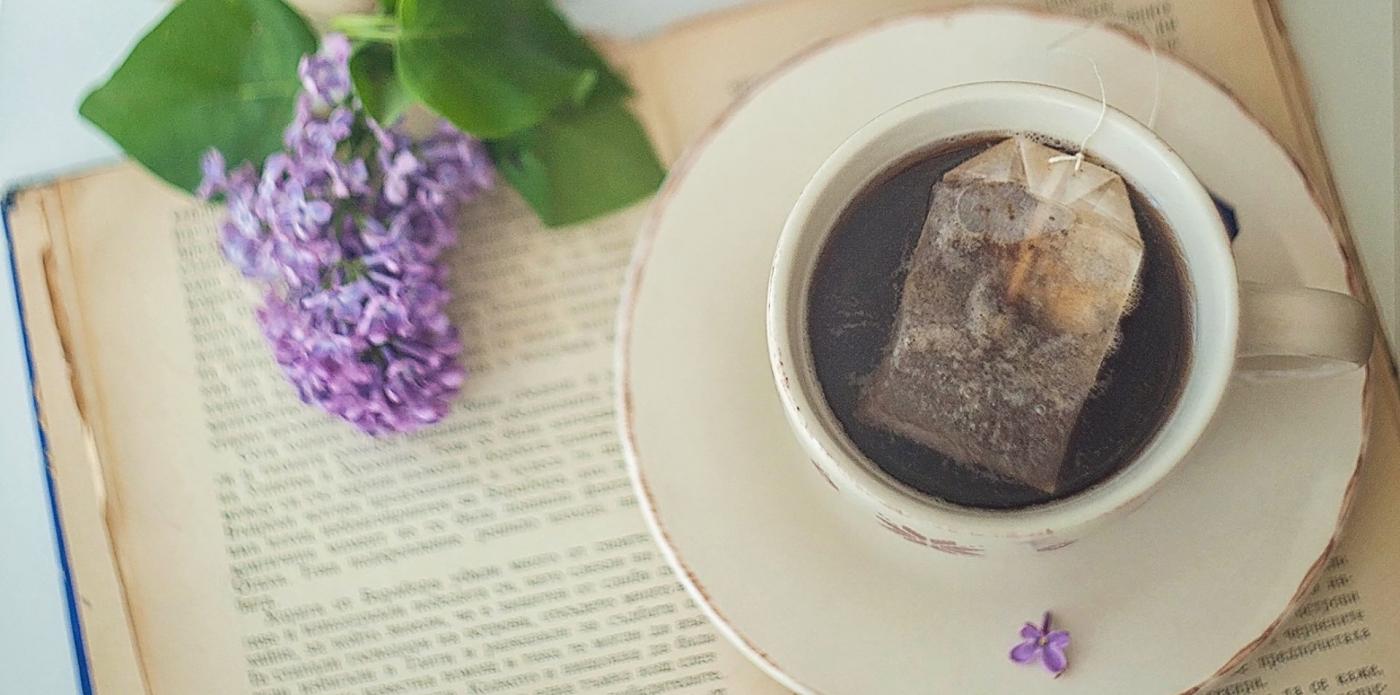 Primo piano di una tazza di tè poggiata sopra un libro aperto