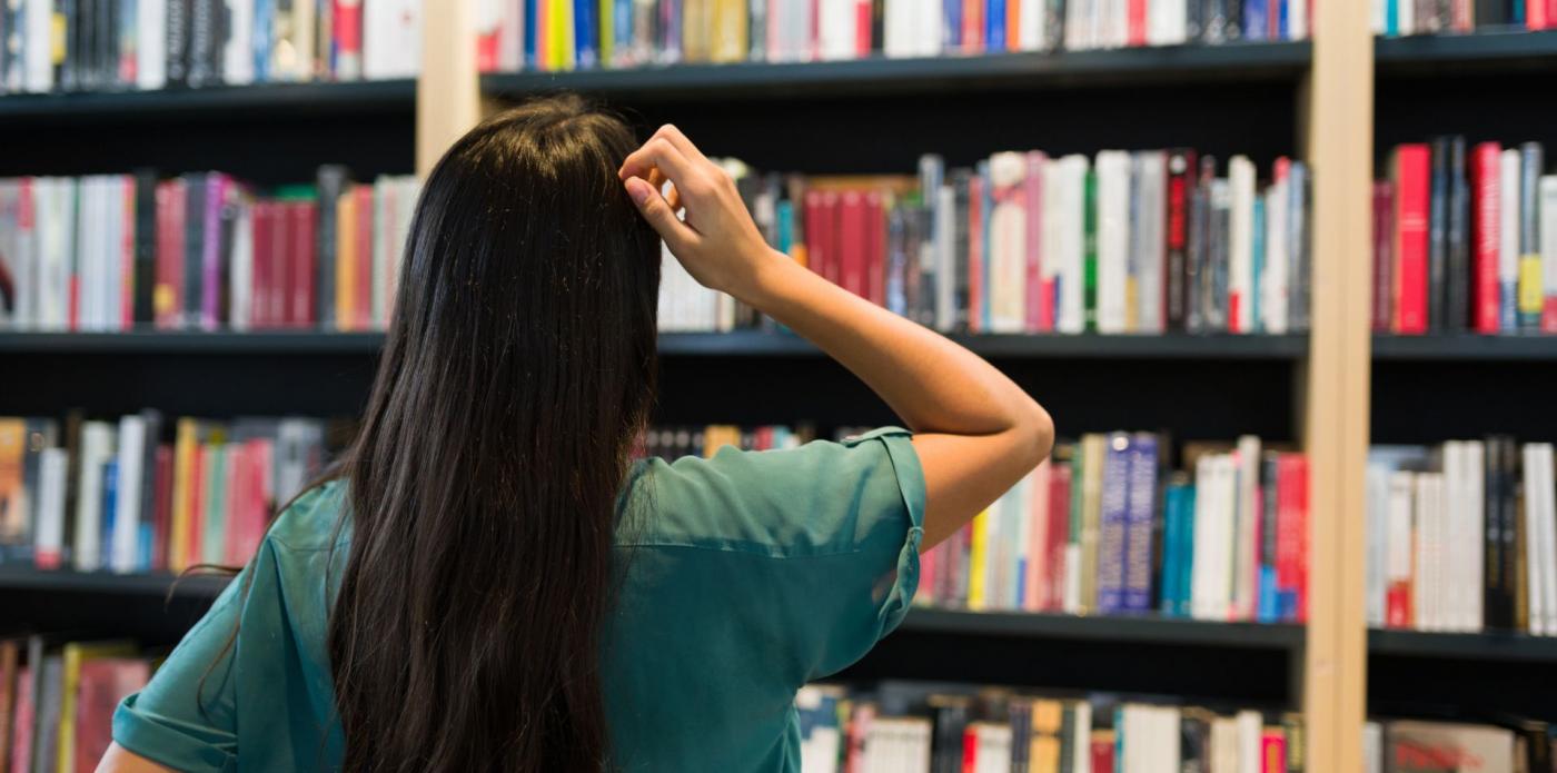 giovane donna sceglie quali libri leggere