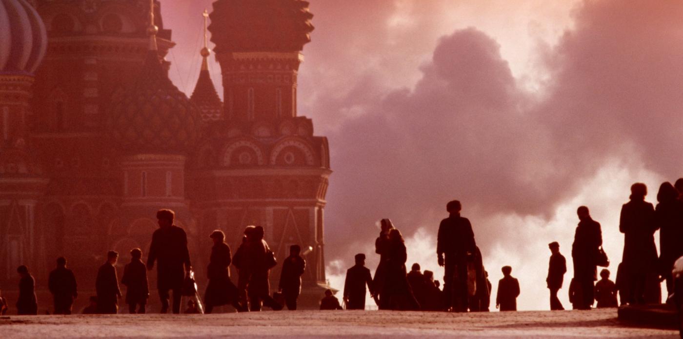 Una foto di Piazza Rossa al tramonto, che mostra in primo piano la silouhette di diversi passanti e, sullo sfondo, un dettaglio della cattedrale di San Basilio (GettyEditorial 08-10-2025)