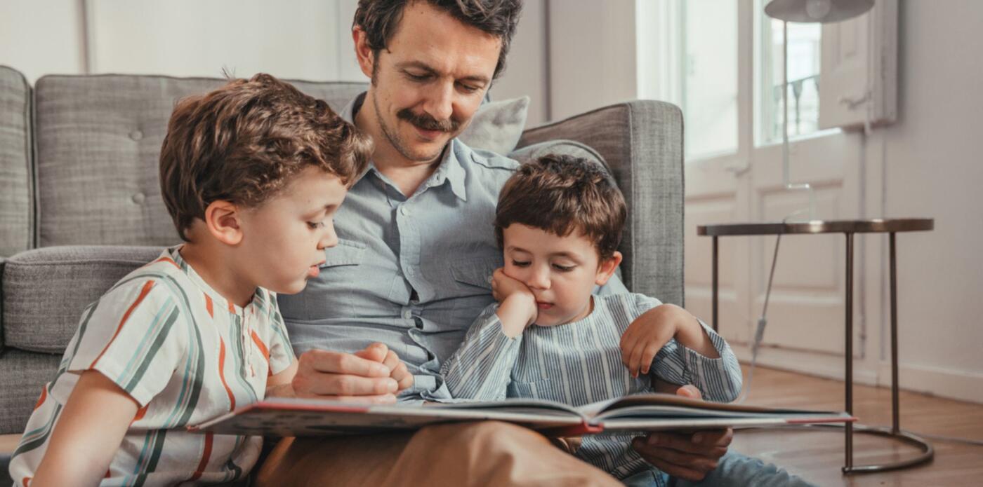 Bambini leggono libri a casa con papà