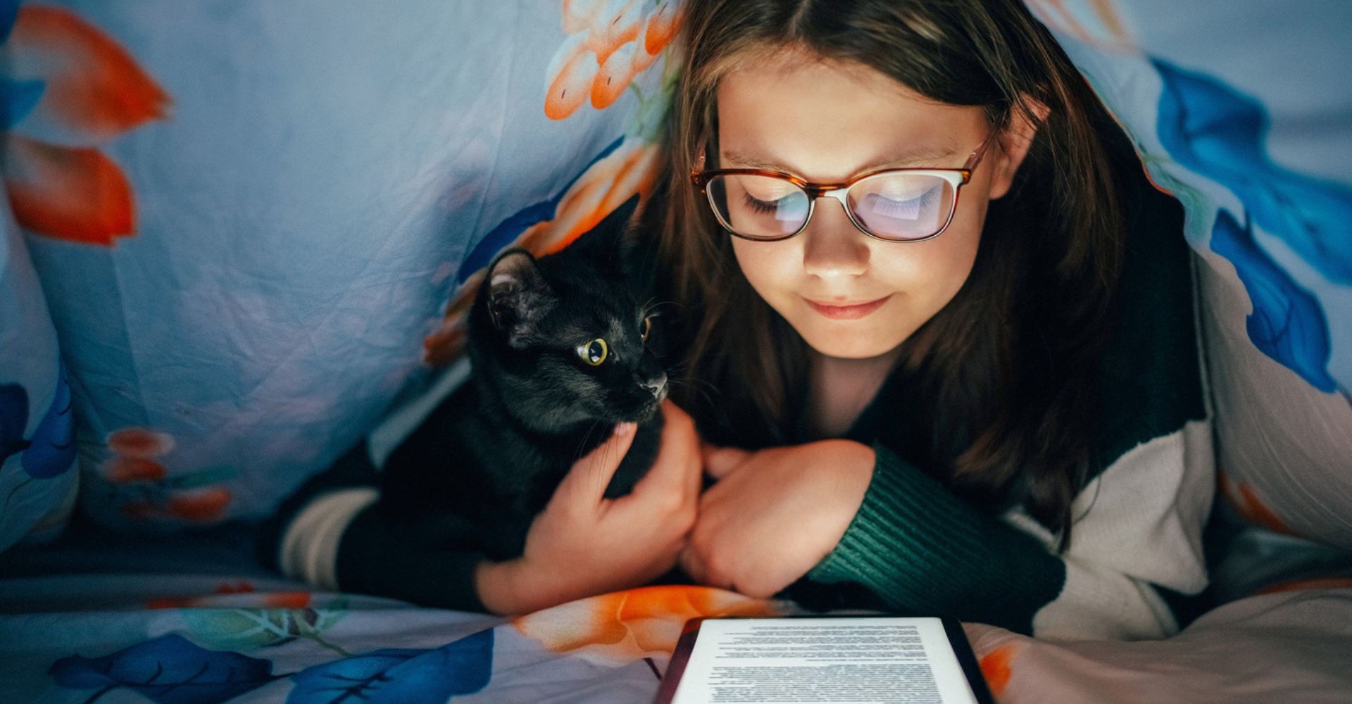 bambina legge ebook con gatto a casa