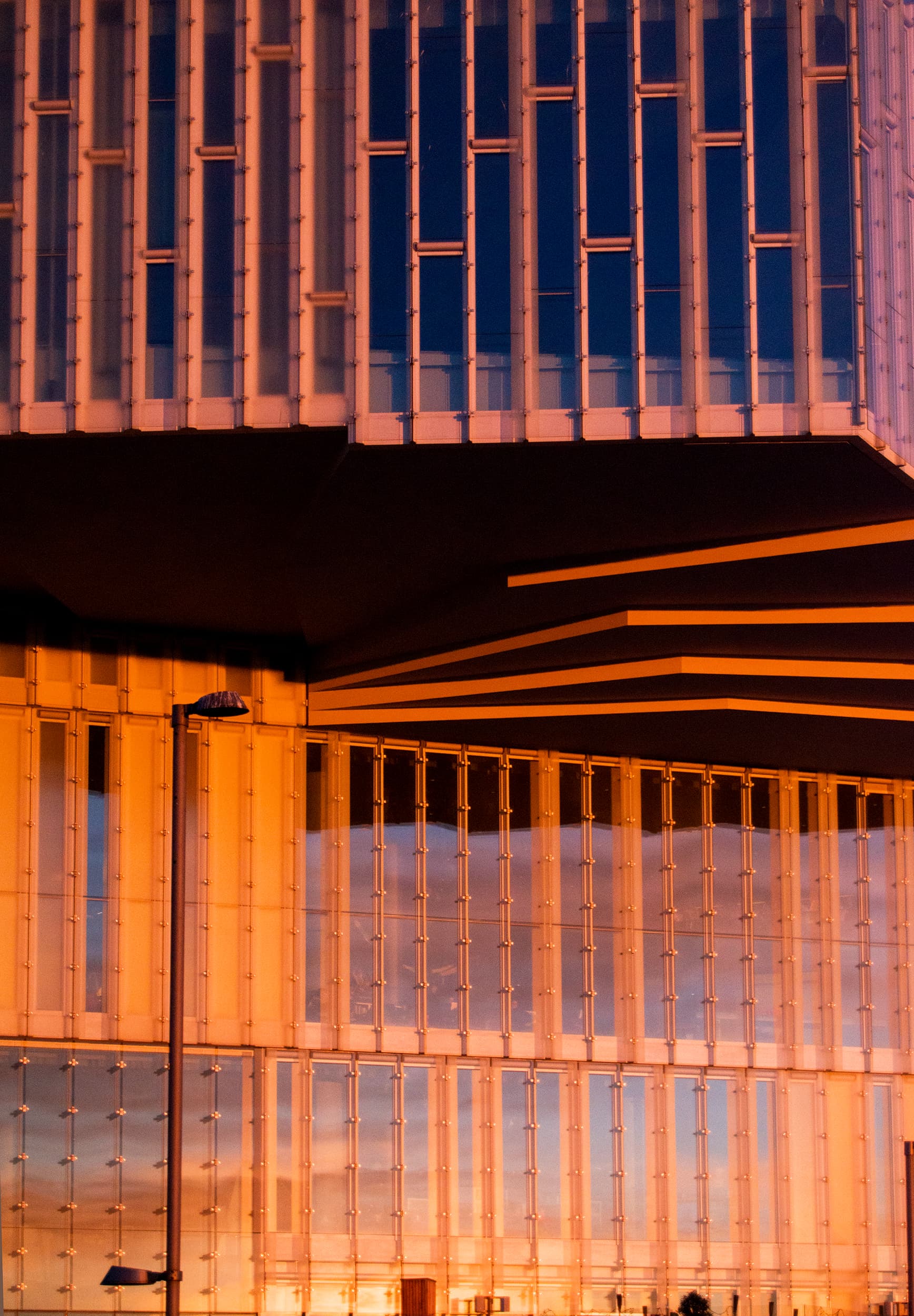 Un dettaglio della Deichman Bjørvika illuminata dalle luci del tramonto invernale